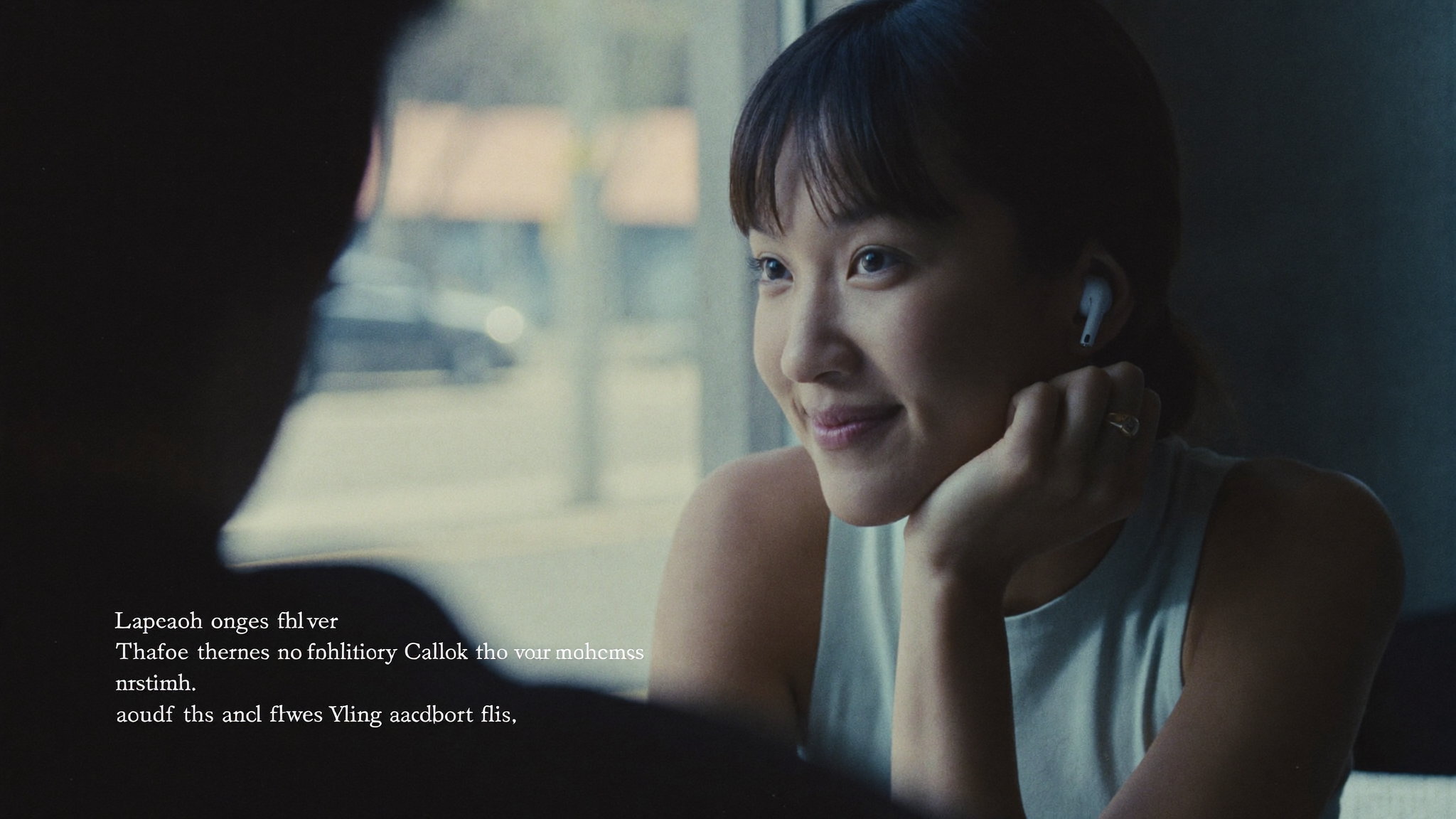 Woman with AirPods in, mid-conversation, lit by window light